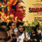 Gente pasando por delante del cartel de la película"Swatantra Veer Savarkar". AP Foto / Rajanish Kakade